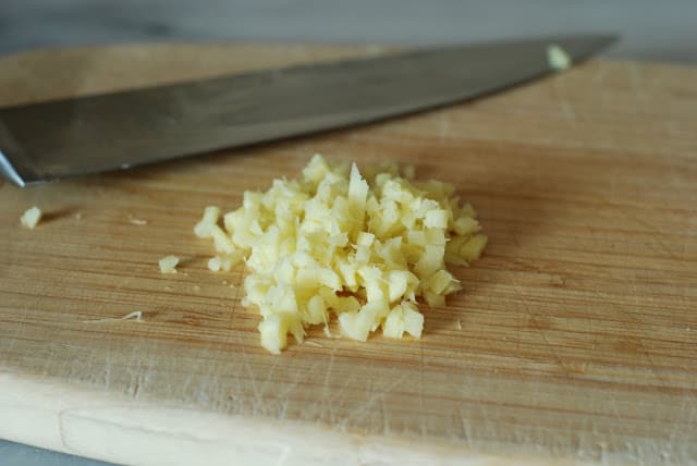 Finely chopped fresh ginger on a cutting board