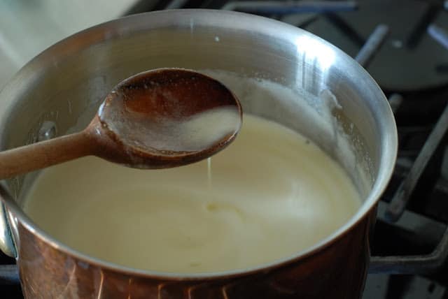 Wooden spoon showing thinning lemon curd