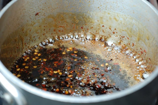 Simmering soy sauce with red pepper flakes in small saucepan