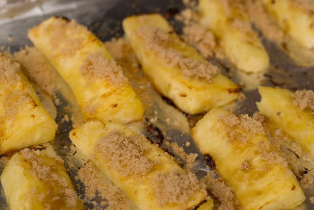 Grilling fresh pineapple slices sprinkled with coconut sugar