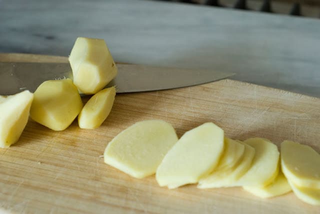 peeled fresh ginger slices on wood board