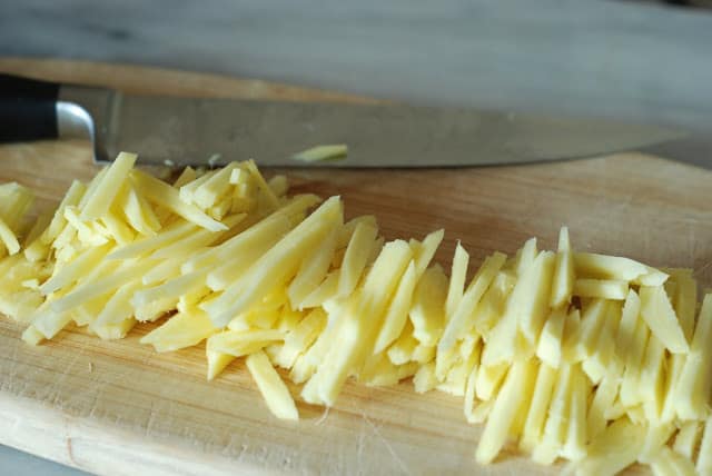 Julienned strips of fresh ginger on cutting board