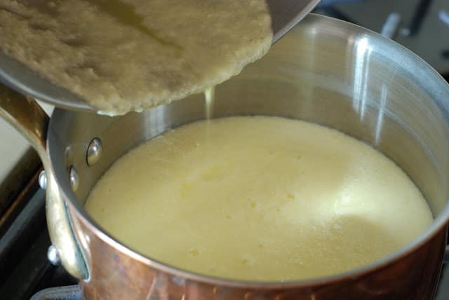 Lemon curd mixture pouring into a pot