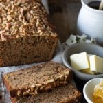 banana nut bread sliced with bowl of butter and honey comb