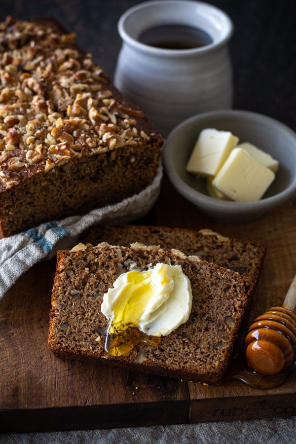 slice of banana nut brad with a spread of butter and honey