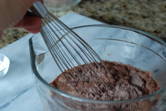 whisk mixing milk, cocoa sugar mixture