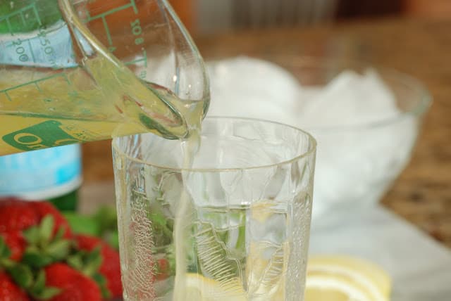 Lemonade syrup pouring into a tall glass