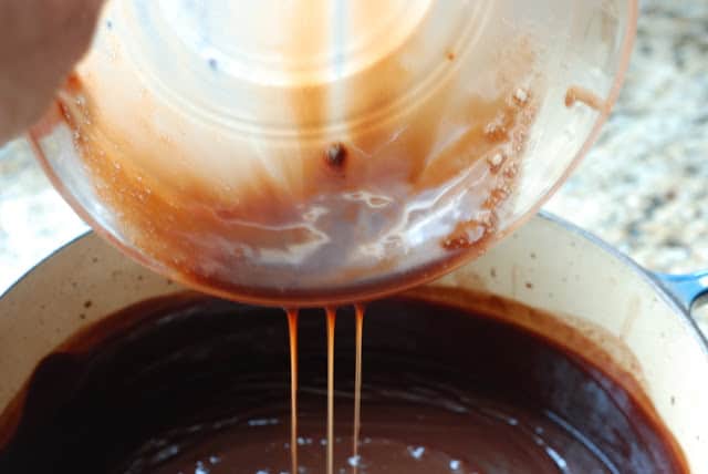 large bowl pouring chocolate mixture into pot