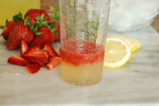 lemonade syrup and strawberry puree in a tall glass