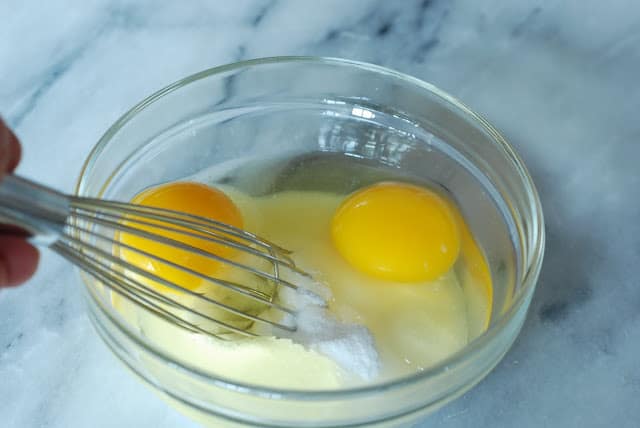 2 eggs in bowl with sugar and whisk