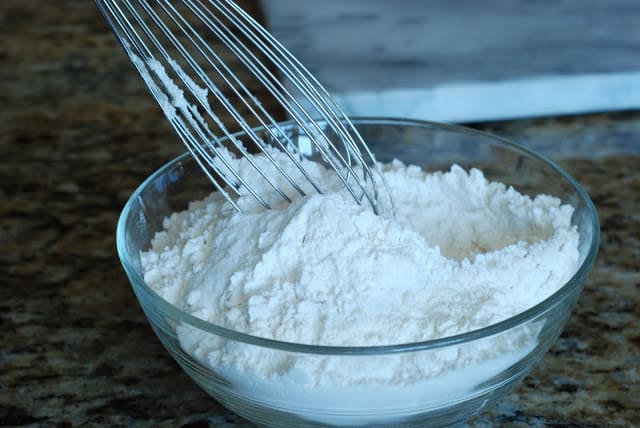 Flour in a bowl with wisk