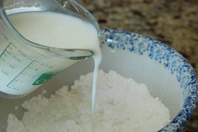 buttermilk pouring into bowl of shortbread ingredients