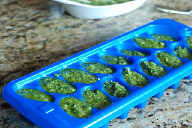 Blue ice cube tray filled with perfect basil pesto