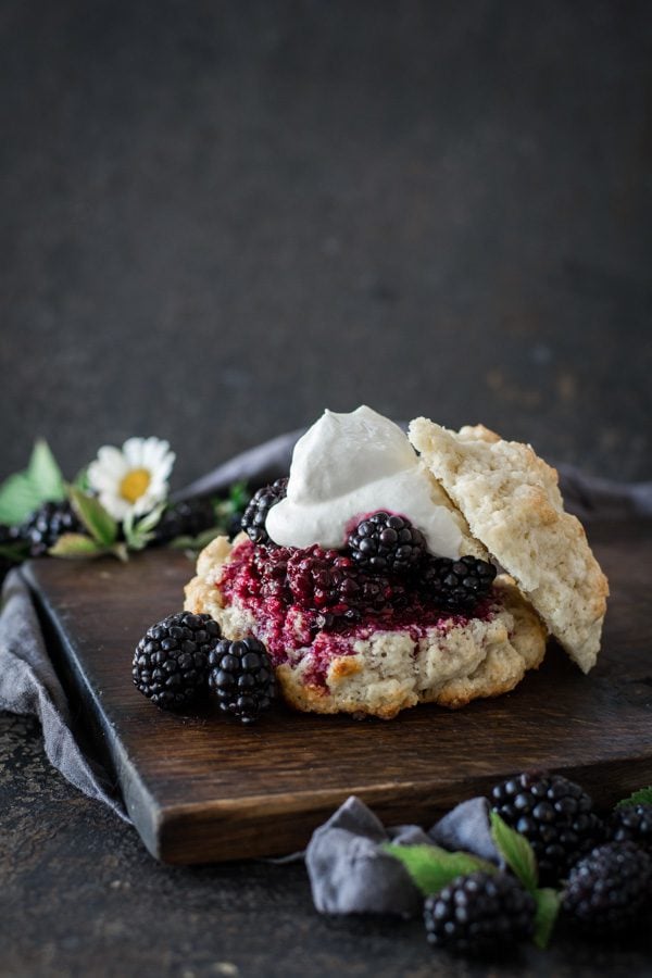 rustic blackberry shortcake on wood board with blackberries as garnish