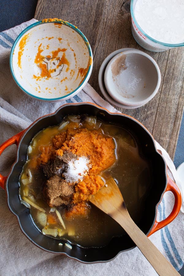 pot with pumpkin and spices added to broth