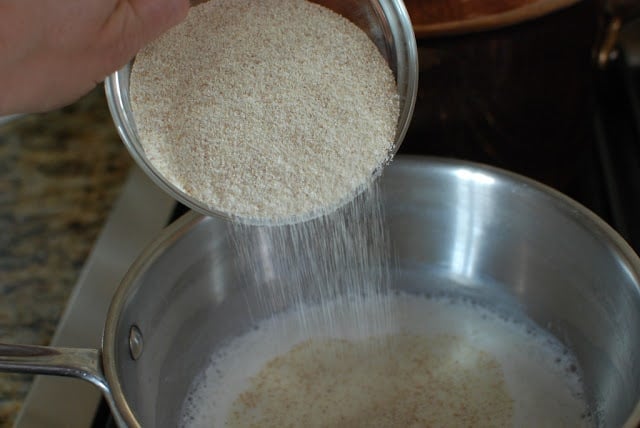 Pot of hot milk with farina pouring into the milk