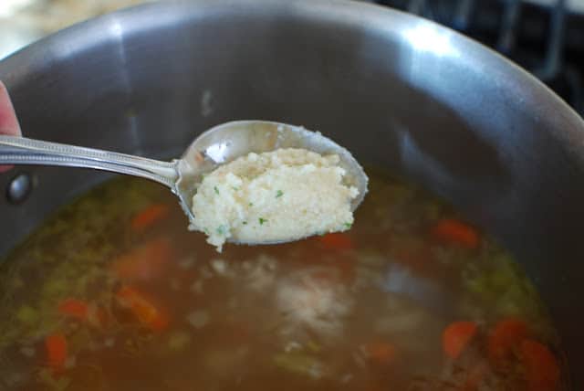 Spooning dumplings into simmering soup