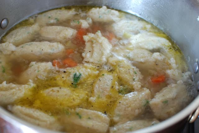 Pot of simmering dumplings in broth