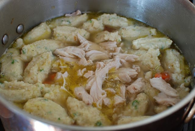 Cooked chicken added to dumplings and soup