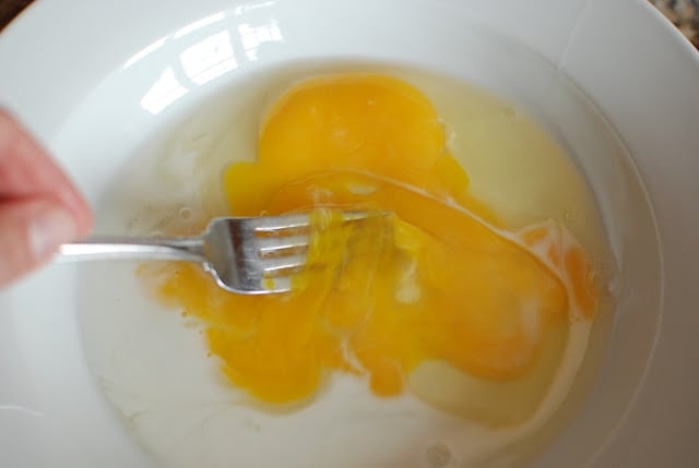 A fork beating egg and mix together