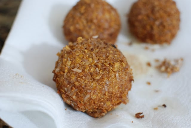 Draining the fried ball of excess oil on a paper towel.