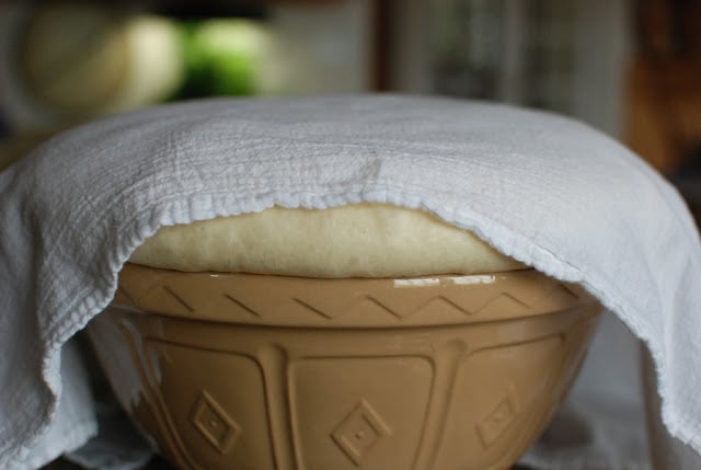 Bowl of risen dough covered with white cloth