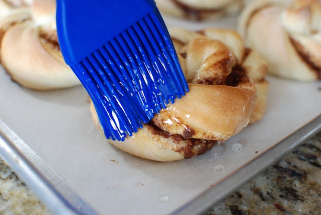 Brushing cinnamon twists with sugar syrup