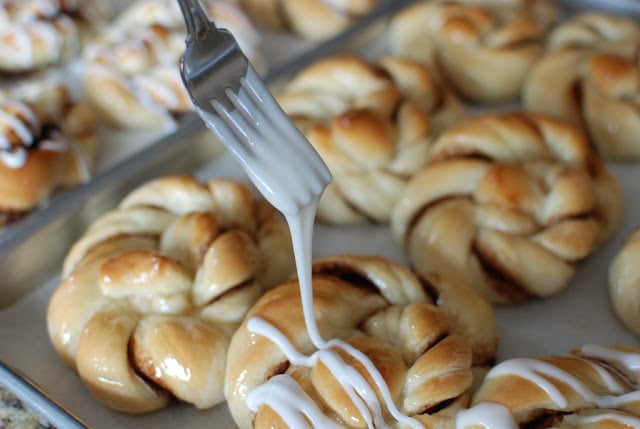 Glaze drizzled from fork over cinnamon twists