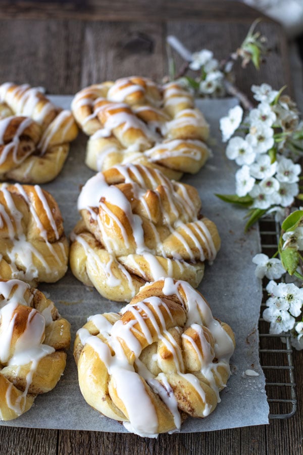 overhead shot of cinnamon twists on wood back drop with spring flowers on the side