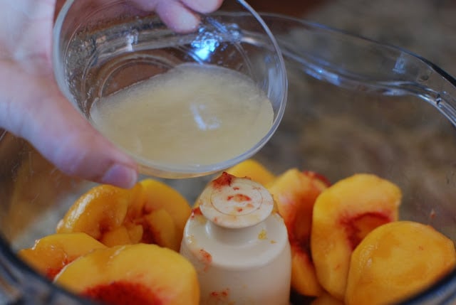 lemon juice pouring over peaches in food processor