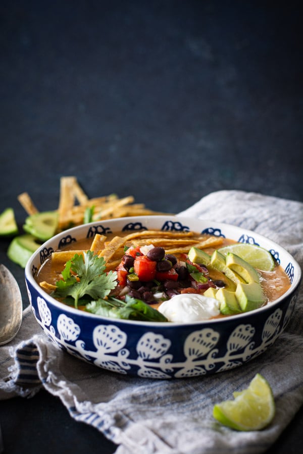 blue and white bowl with turkey tortilla soup with toppings