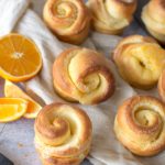 baked orange rolls on cloth with orange zest