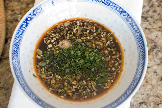 Chopped cilantro in bowl with dipping sauce