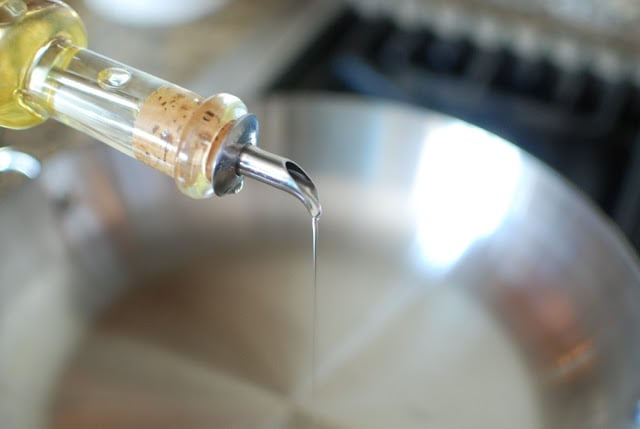 Oil being drizzled in a pan