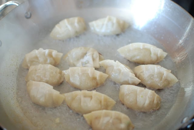 Potstickers steaming in pan