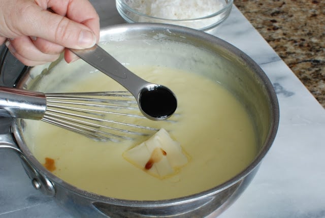 Vanilla and butter added to custard mixture in saucepan