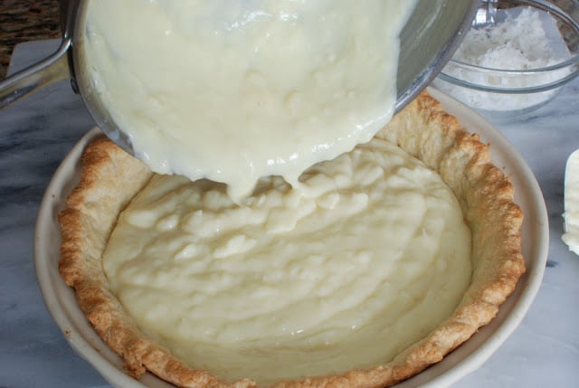 Coconut Custard pouring into cooked pie crust