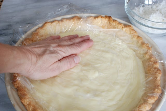 plastic wrap pressed onto coconut custard pie