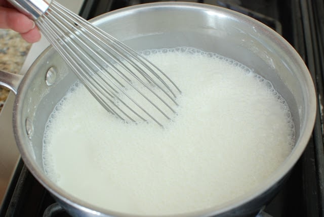 Wire whisk stirring cream mixture while cooking
