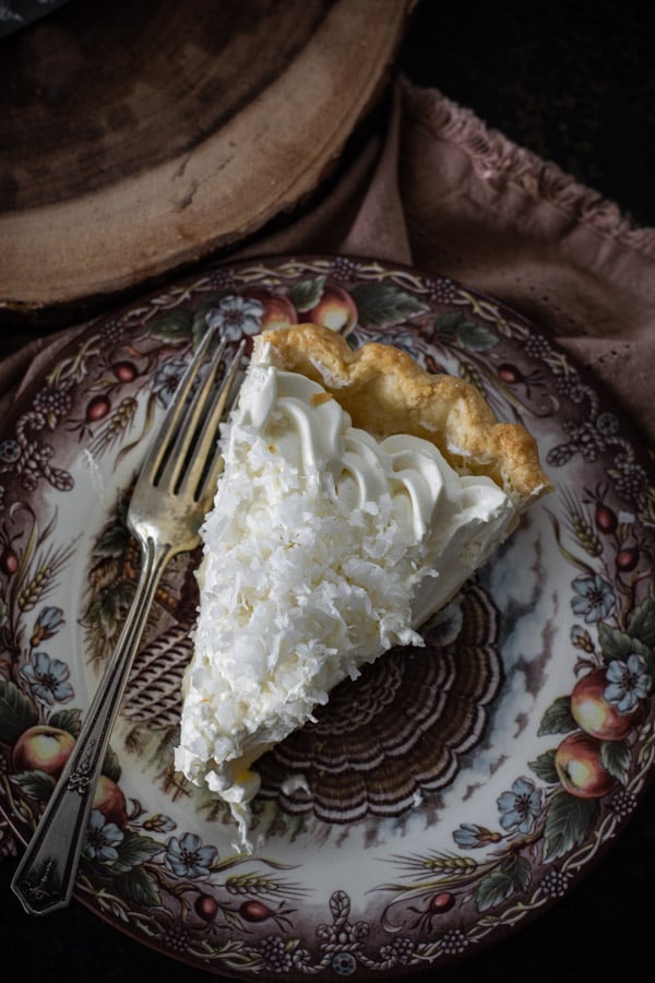 Over head shot of one slice coconut cream pie on a decorative plate