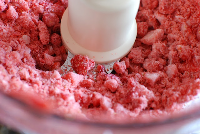 Adding frozen chopped fruit to the food processor.