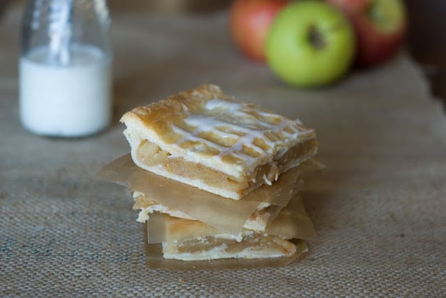 Slab Apple Pie squares stack between waxed paper