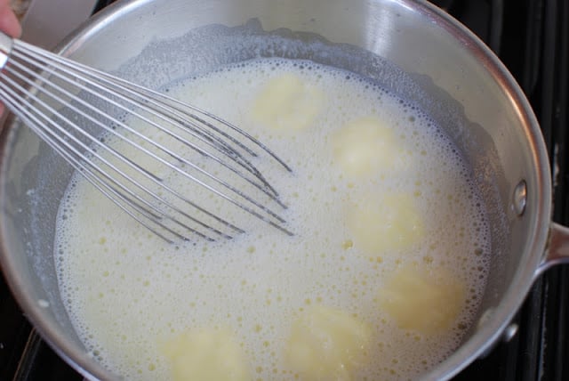 whisk stirring milk, mashed potato, butter mixture in saucepan.