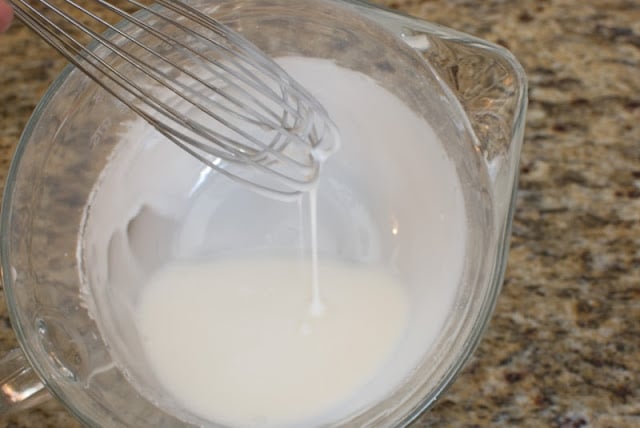Vanilla glazed mixed dripping from wire whisk