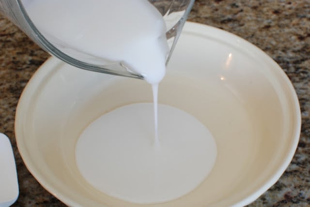 Vanilla glaze pouring into a shallow pie dish