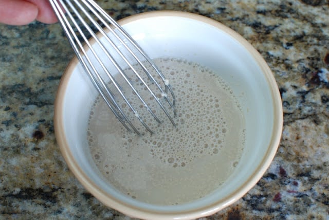wire whisk stirring water yeast mixture