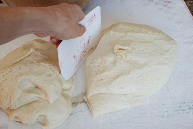 Spudnut dough cut int half on floured surface