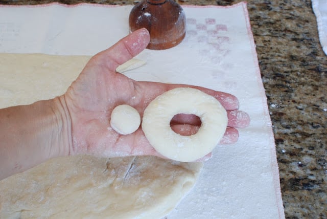 A hand holding cut spudnut and donut hole