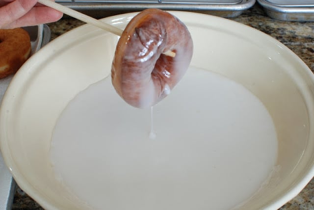 glazed spudnut lifing out of glaze with chopstick