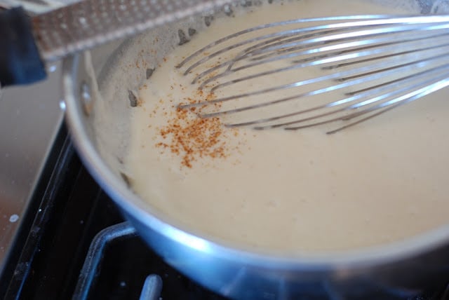 Nutmeg being whisked into cream mixture